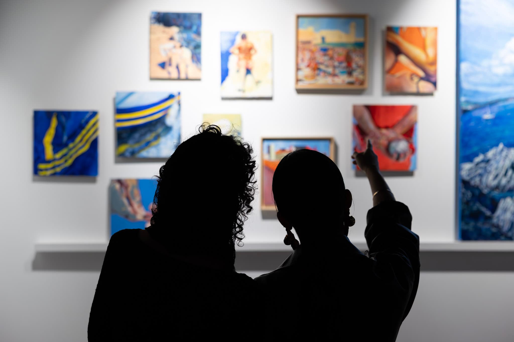 Deux visiteuses devant un mur d'œuvres colorées à la galerie du 3ème Cercle, Paris 11
