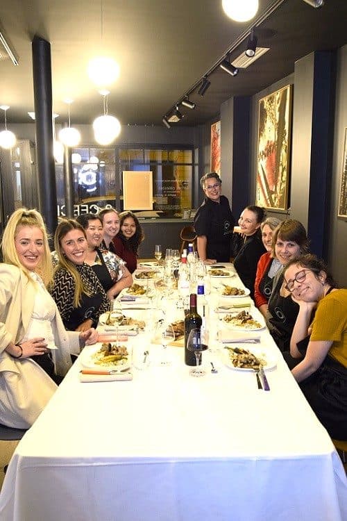 Convives réunis à une grande tablée dans la galerie du 3ème Cercle après l'atelier de cuisine, Paris 11