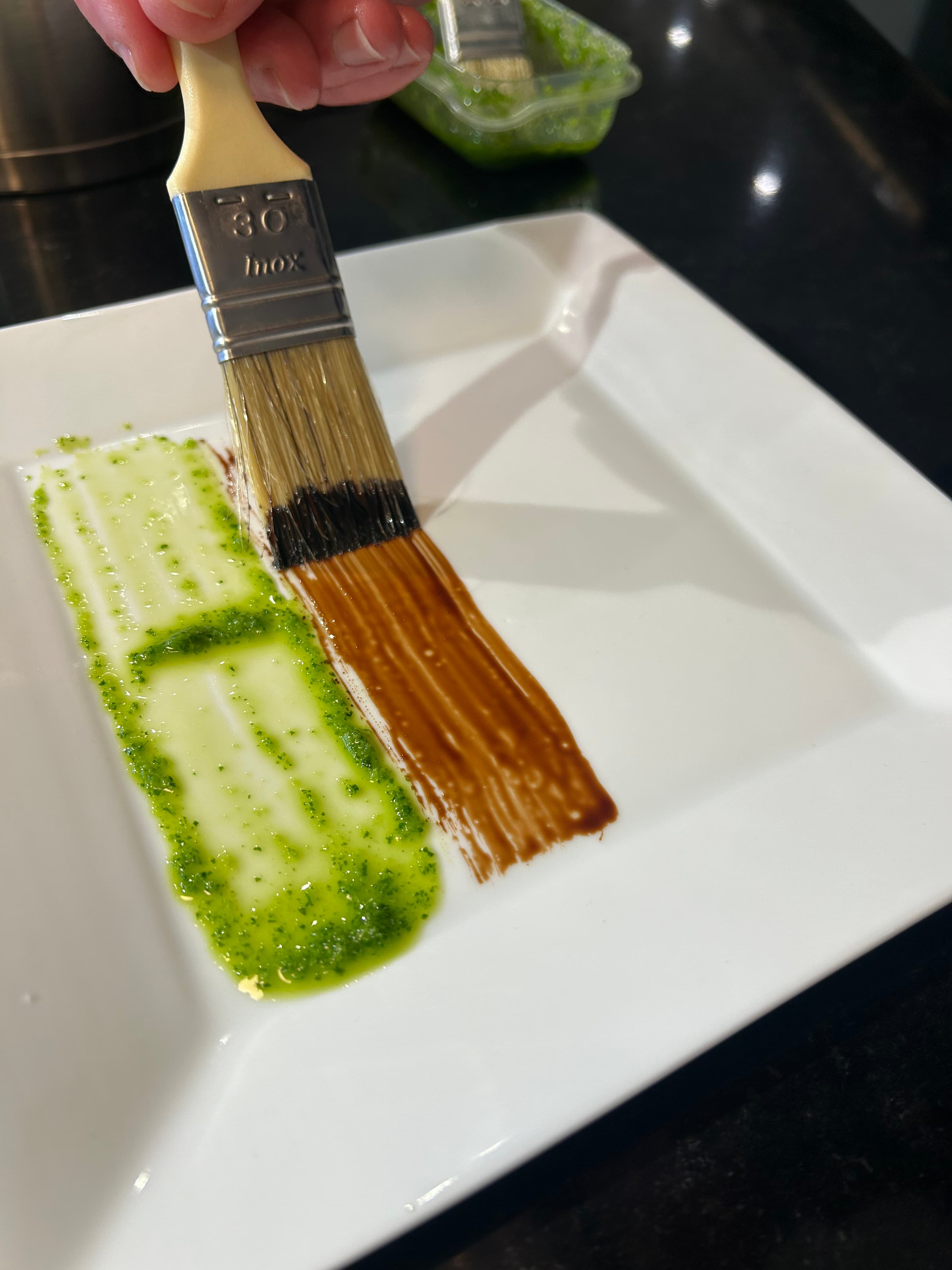Trait de sauce tracé au pinceau sur une assiette lors de l'atelier Cuisine & Art au 3ème Cercle